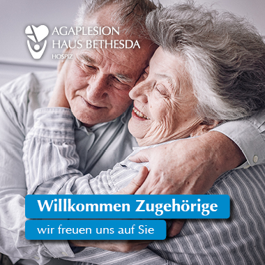 Foto von einem alten Ehepaar, dass sich umarmt und lächelt